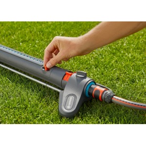 Prostokątny zraszacz Gardena AquaZoom S w użyciu na trawniku, zbliżenie na regulację.