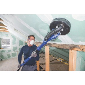 Mężczyzna szlifuje sufit niebieską szlifierką do płyt gipsowo-kartonowych. Kategoria: Szlifierki.