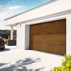 Nowoczesny garaż z brązową bramą garażową t.b.t. o wyglądzie drewna przed białym domem.