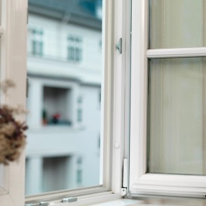 Otwarte białe okno z okuciami. Akcesoria okienne.