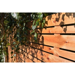 Drewniany płot t.b.t. z roślinnością, naturalny wygląd do ogrodu.