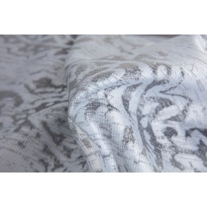 Zbliżenie białej zasłony z abstrakcyjnym wzorem.