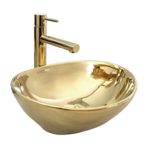 Złota umywalka nablatowa z baterią do łazienki.