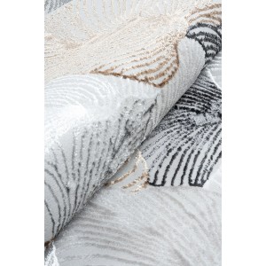 Zbliżenie zwiniętego, jasnego dywanu z abstrakcyjnym wzorem.