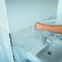 Okładziny łazienkowe i umywalka zaklejone i przykryte folią ochronną do malowania.
