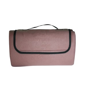 Złożony różowy koc piknikowy t.b.t. z uchwytem do przenoszenia na wycieczki kempingowe.