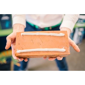 Na cegłę nałożono dwa paski kleju.