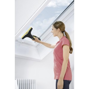 Kobieta czyści okno za pomocą Kärcher WV 2 Premium 10 Years Edition.