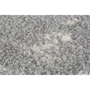 Zbliżenie szarego dywanu t.b.t. z długim włosiem i jasnym wzorem.