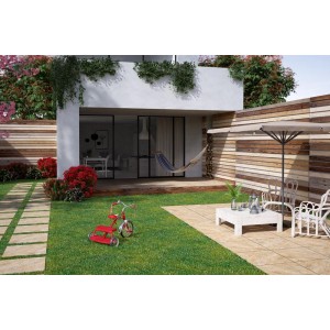 Taras z płyt tarasowych t.b.t., meble ogrodowe i czerwony trójkołowiec na trawniku.