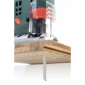 Zbliżenie wyrzynarki z brzeszczotem t.b.t. podczas cięcia drewna.