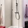 Czarny system prysznicowy Grohe QuickFix Vitalio Start 250 z termostatem w nowoczesnym prysznicu.