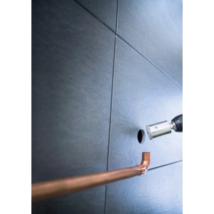 Wiercenie otworu w szarych płytkach otwornicą t.b.t., przygotowana rura miedziana.