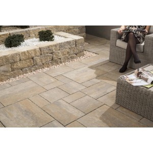 Ułożona kostka brukowa t.b.t. w kolorze beżowo-szarym na tarasie z miejscem do siedzenia.