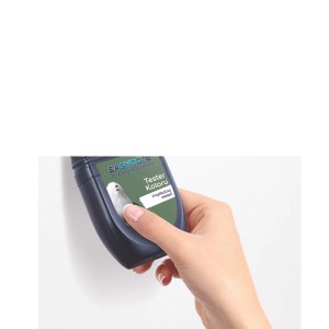 Ręka testuje zieloną farbę ścienną za pomocą testera kolorów. Kolorowe farby do ścian.