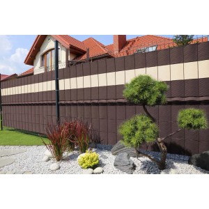 Brązowa i beżowa mata na ogrodzenie z roślinami ogrodowymi.