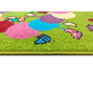 Zbliżenie zielonego dywanu z krótkim włosiem i kolorowymi, okrągłymi wzorami.