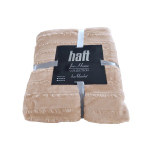 Beżowy koc t.b.t. z frędzlami, złożony i przewiązany wstążką.