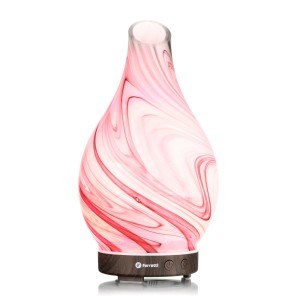 Nawilżacz powietrza t.b.t. z różowym efektem marmuru i drewnianą podstawą.