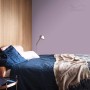 Sypialnia z farbą do ścian w kolorze liliowym. Kolorowa farba do ścian dla przytulnej atmosfery.
