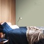 Sypialnia z farbą ścienną w delikatnym odcieniu zieleni. Kolorowa farba ścienna dla relaksującej atmosfery.