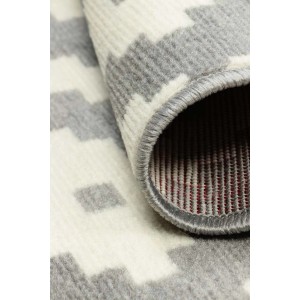 Zbliżenie dywanu z krótkim włosiem o wzorze szaro-białym.