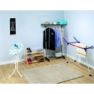 Scena pralni z deską do prasowania, suszarką na ubrania, wieszakiem na ubrania i pudełkami do przechowywania.