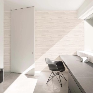 Jasna tapeta dekoracyjna t.b.t. w nowoczesnym pokoju z krzesłem i drzwiami przesuwnymi.