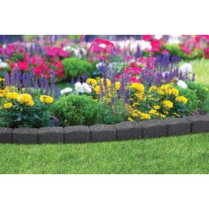 Ogród z kwiatami i szarym obrzeżem.