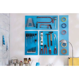 Ściana narzędziowa z różnymi narzędziami, takimi jak śrubokręty, szczypce, piły i taśmy klejące.