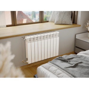 Biały grzejnik t.b.t. pod oknem w sypialni.