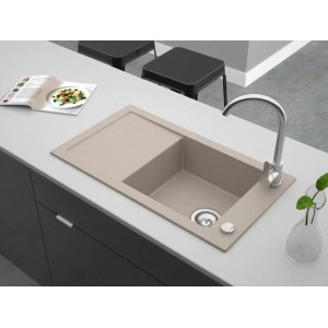 Beżowy zlewozmywak granitowy t.b.t. z ociekaczem i baterią na blacie kuchennym.