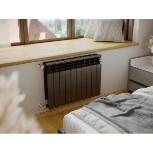 Brązowy grzejnik t.b.t. zamontowany na ścianie w sypialni.