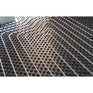 Montaż ogrzewania podłogowego t.b.t. na czarnej płycie z wypustkami.