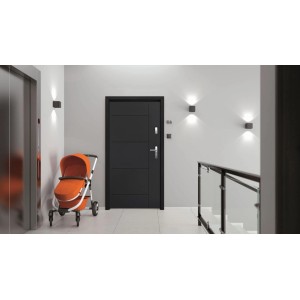 Nowoczesne szare drzwi zewnętrzne (t.b.t.) w jasnym korytarzu z wózkiem dziecięcym.