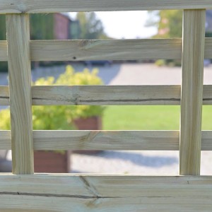 Zbliżenie elementu drewnianego ogrodzenia. Tekstura drewna i zielone otoczenie w tle.