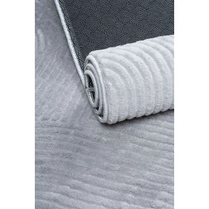 Szary, zwinięty dywan z krótkim włosiem, wzorem i antypoślizgowym spodem.