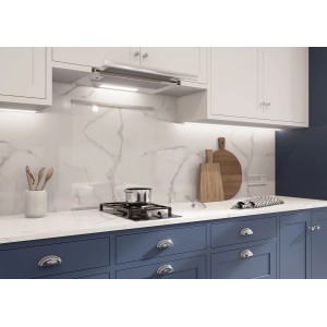 Scena kuchenna z okapem i płytą grzejną na tle marmurowej ściany