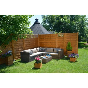 Drewniany płot w ogrodzie z meblami wypoczynkowymi i skrzynkami na kwiaty. Ekran prywatności na patio.