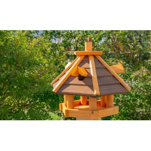 Drewniany karmnik dla ptaków z brązowym dachem do ogrodu.