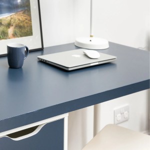 Folia samoprzylepna t.b.t. na biurku z laptopem, kubkiem i lampą.