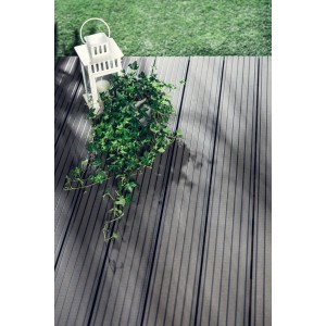 Szare deski tarasowe t.b.t. z dekoracyjnym lampionem i bluszczem na tarasie.