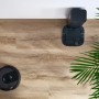 Robot odkurzający ze stacją ładującą na jasnej podłodze winylowej obok rośliny doniczkowej.