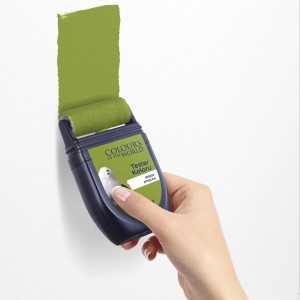 Ręka z wałkiem do malowania ścian. Aplikacja zielonej farby.