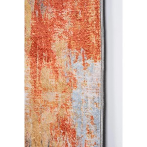 Zbliżenie dywanu z krótkim włosiem o abstrakcyjnym wzorze w kolorach pomarańczowym, beżowym i niebieskim.