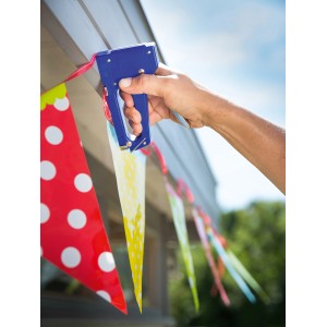 Ręka mocuje girlandę do drewnianej listwy za pomocą zszywacza LUX Kombitacker Classic.