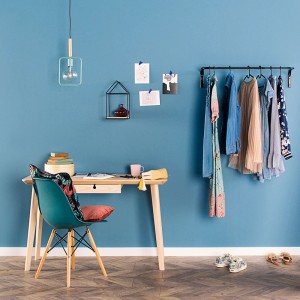 Niebieski pokój z biurkiem, wieszakiem na ubrania i kolorowymi farbami do ścian.