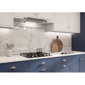 Nowoczesna kuchnia z okapem i płytą grzewczą na tle marmurowej ściany.