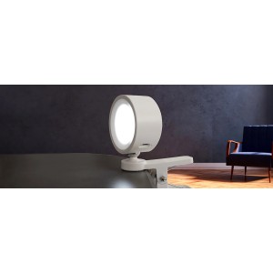 Biała lampka z klipsem t.b.t. na stole, nowoczesny design.