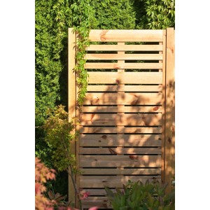 Drewniany panel ogrodzeniowy z poziomymi listwami i zielenią w ogrodzie.